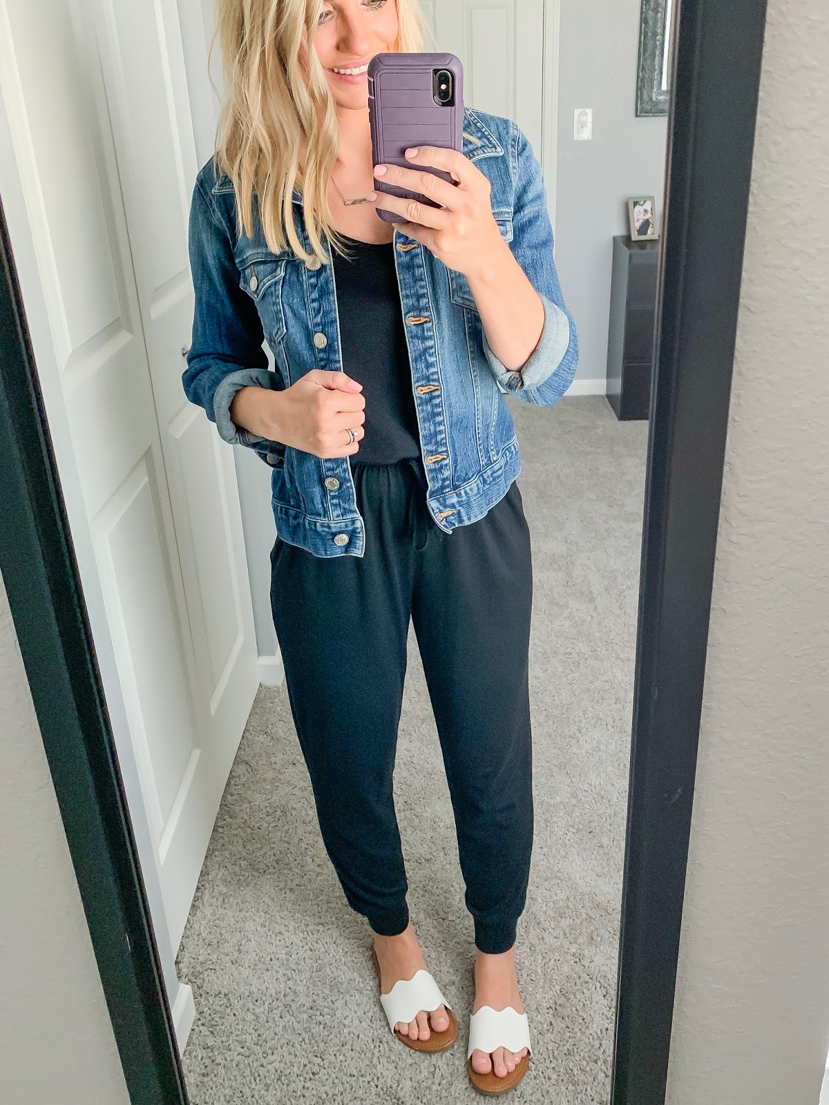 Black jumpsuit styled with a denim jacket