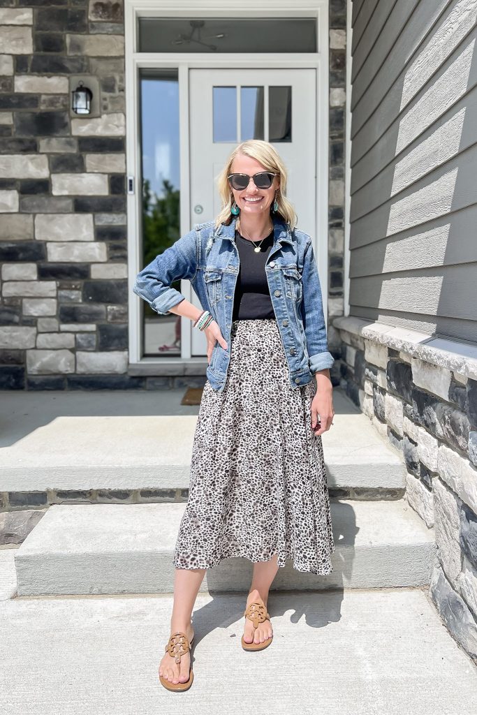 Cute mom outfit with a leopard pleated skirt and denim jacket.