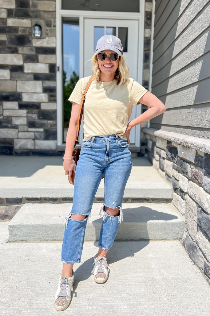 Cute mom outfit idea with distressed jeans and a t-shirt.