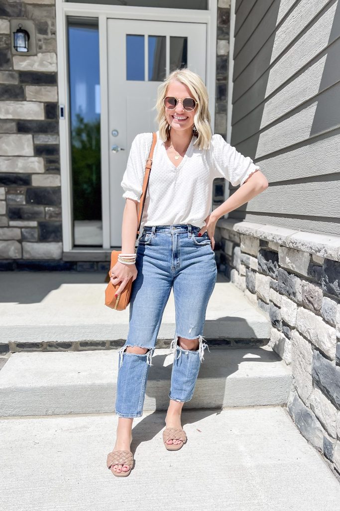 Cute mom outfit with distressed jeans and a white top.