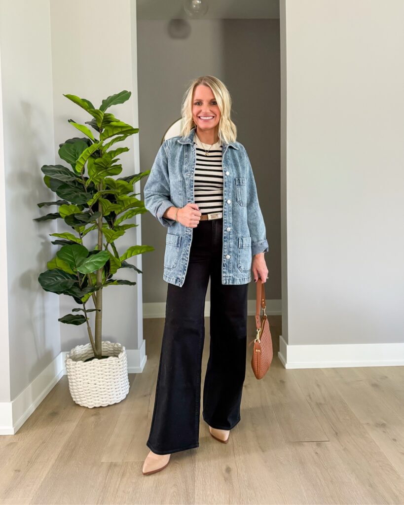 Katie wearing a chambray button-down shirt with a cream sweater draped over her shoulders and black wide-leg jeans for a preppy black jeans fall outfit