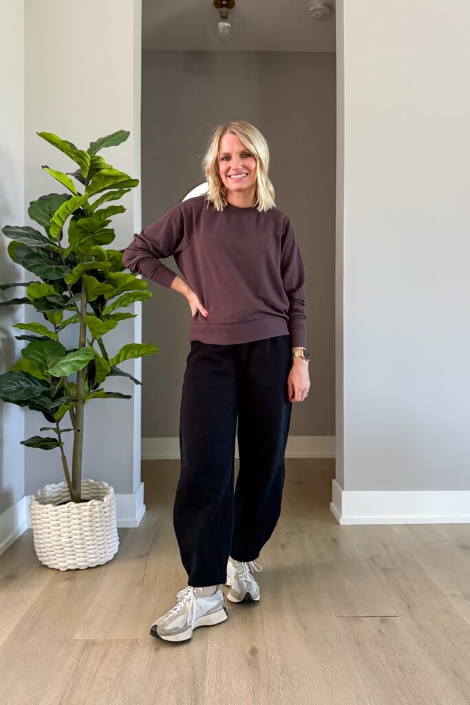 Brown sweatshirt with black wide-leg pants and chunky sneakers